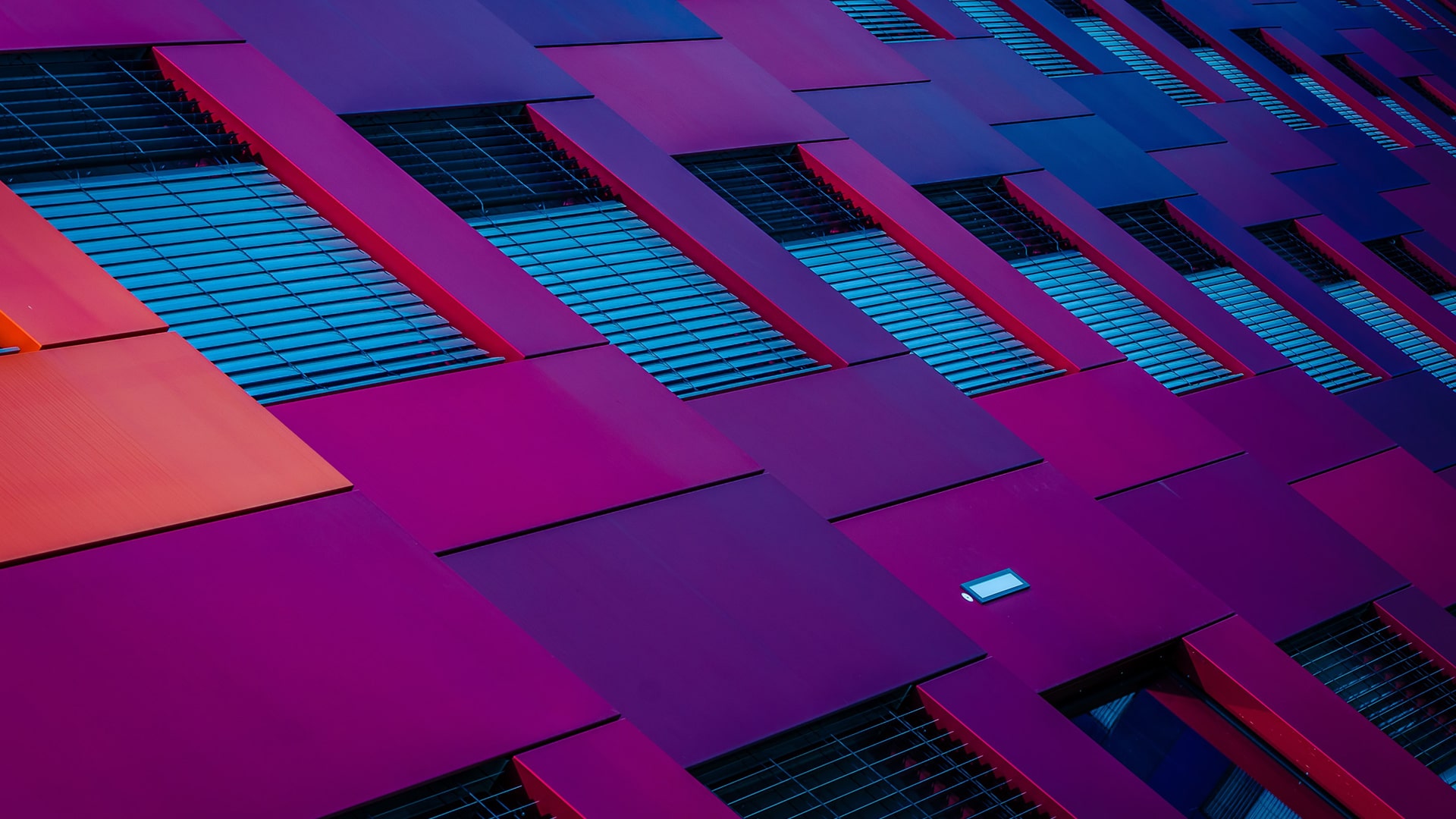 Windows with the blinds shut on a purple wall